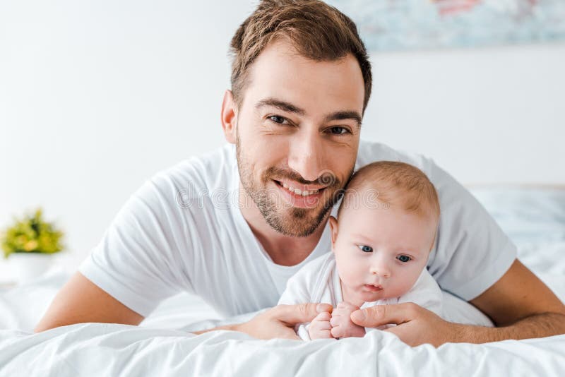 Father Lying on Bed with Baby in Bedroom Stock Photo Image of beard