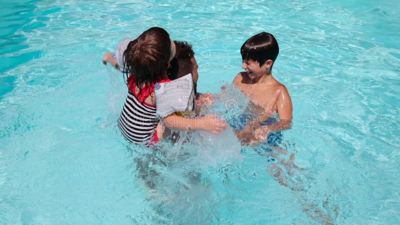 Father with children having fun in swimming pool