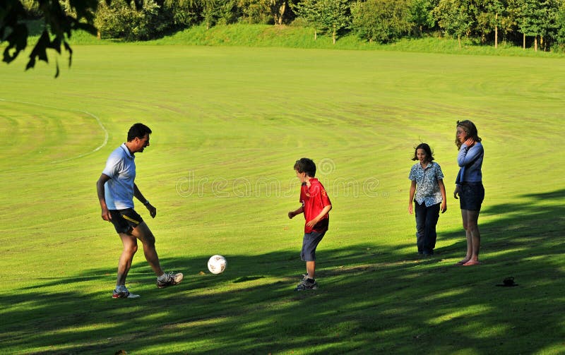 Father playing football with children