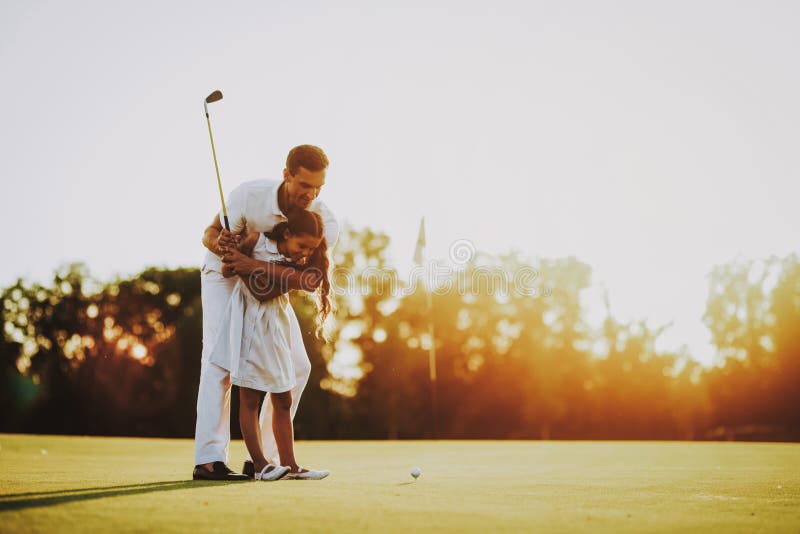 Father Playing Golf with Little Daughter on Field.