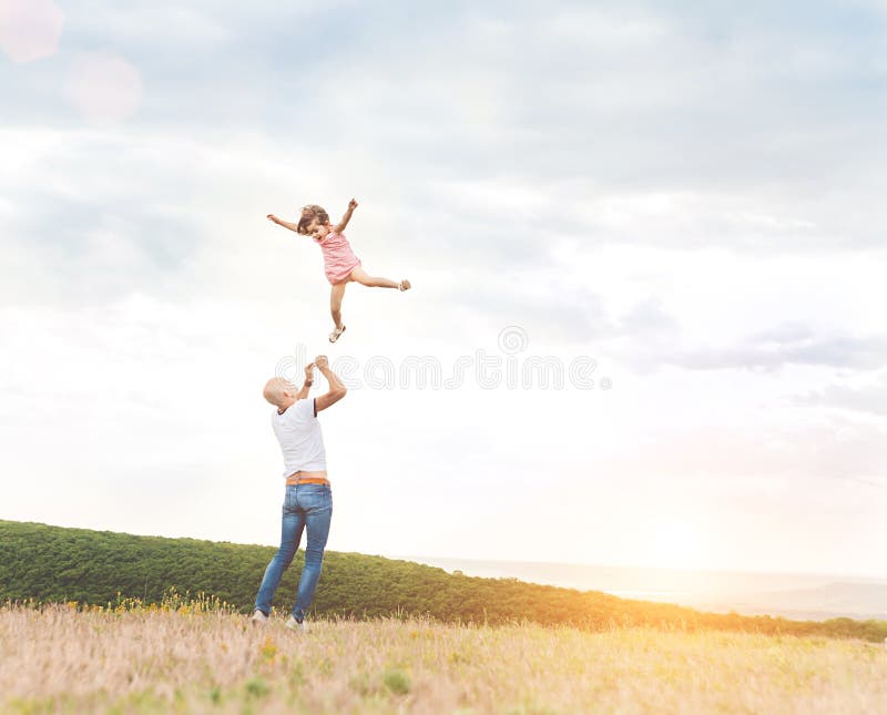 Father playing with his daughter in sunny field