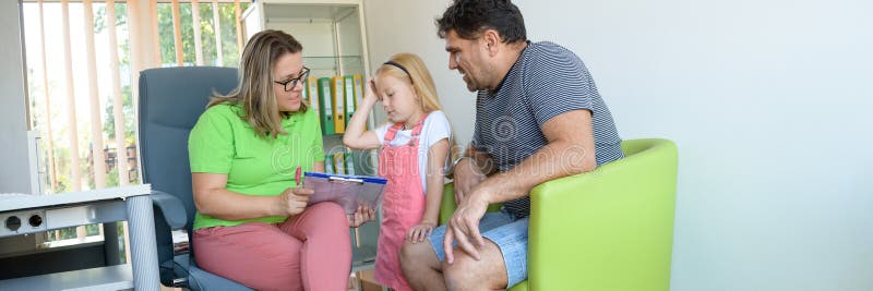 Father and preschooler daughter in therapist office during counselling assessment meeting. Social worker talking to single father.