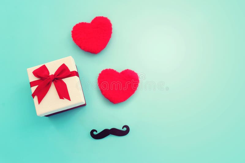 Father's day concept. present box and red fluffy hearts over blue background. top view, flat lay stock photos