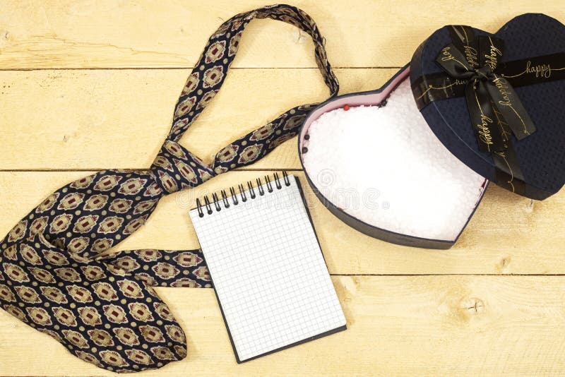 Father`s day concept - present, tie and empty notebook on wood table. royalty free stock photography
