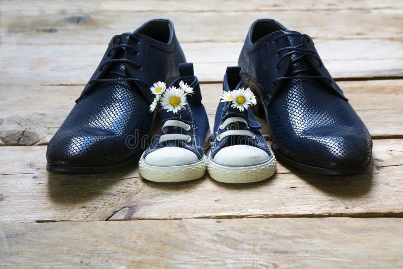 Father s day, kids sneakers with a bouquet of daisies standing b