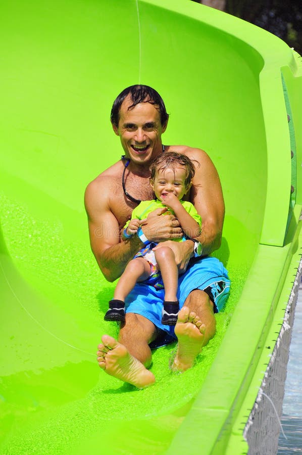 Father and son enjoying a water slide. royalty free stock photos