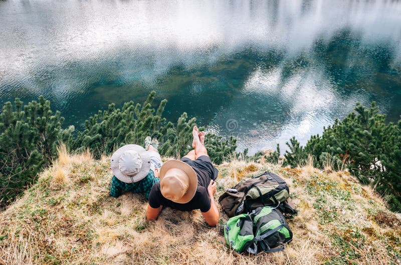 Father and son backpackers relax after long walk near the beautiful lake royalty free stock photos Father and son backpackers relax after long walk near the beautiful lake royalty free stock photos