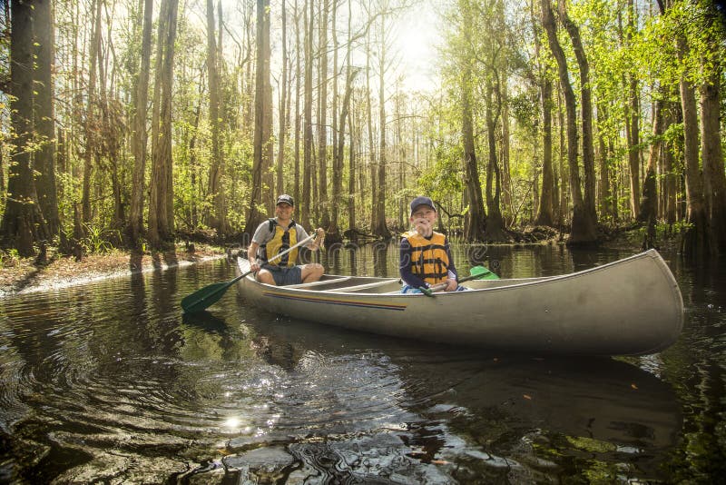 Father and son canoeing together in a tropical river