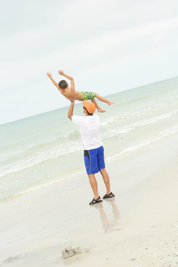 Father & son having fun at the beach vertical