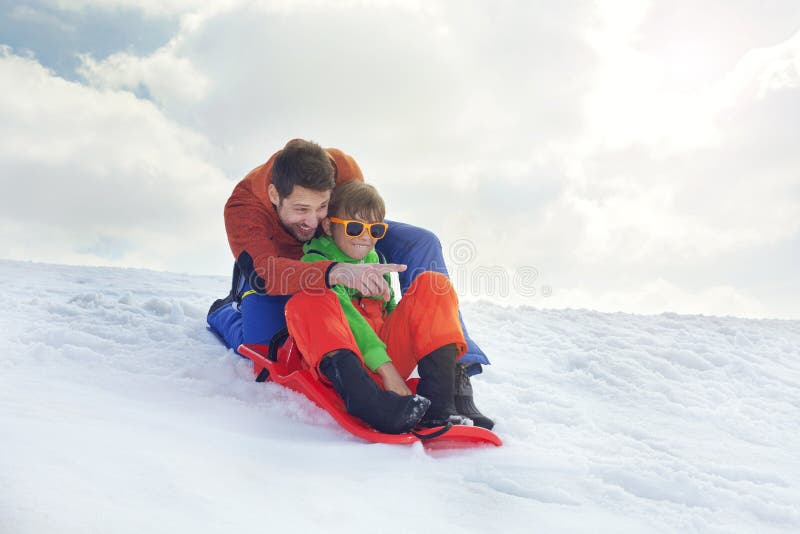 Father and Son Having Fun in the Snow, Sliding Stock Photo Image of