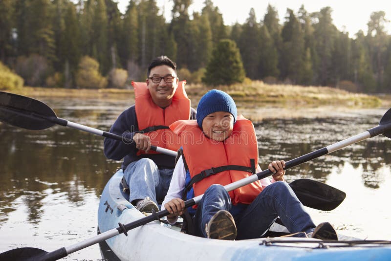 Father and son kayaking on a rural lake, front view stock photos