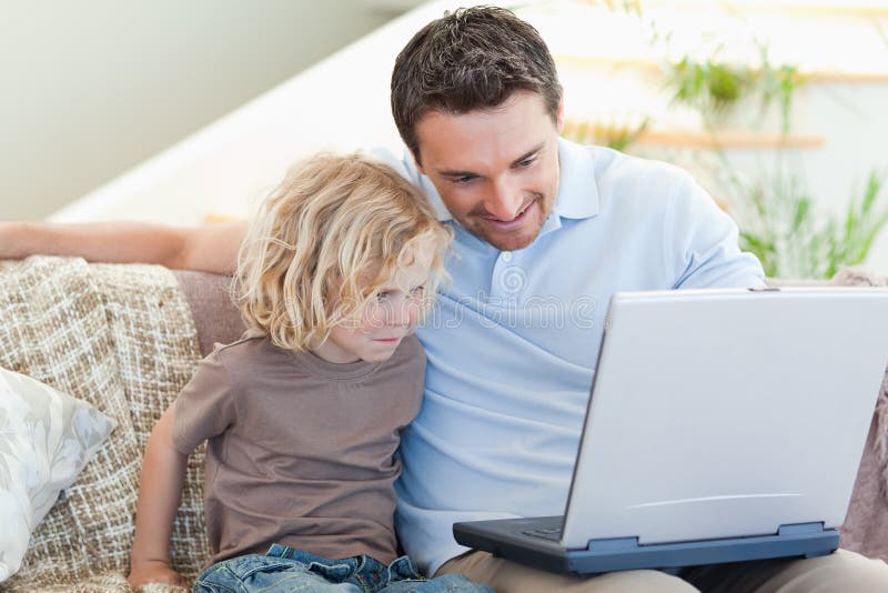 Father and son with laptop on the sofa