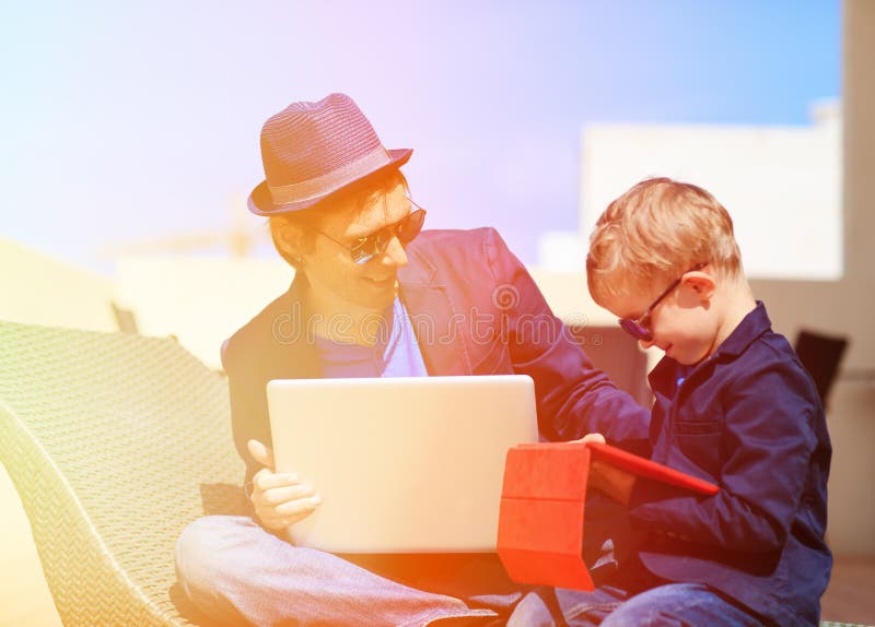 Father and son with laptop, touch pad in the city