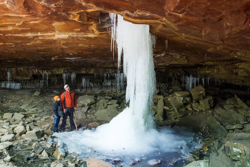 Father and son looking at the frozen waterfall Glory Hole Falls.