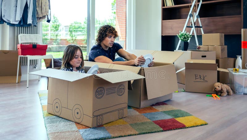 Father and son playing car racing with cardboard boxes stock photos Father and son playing car racing with cardboard boxes stock photos