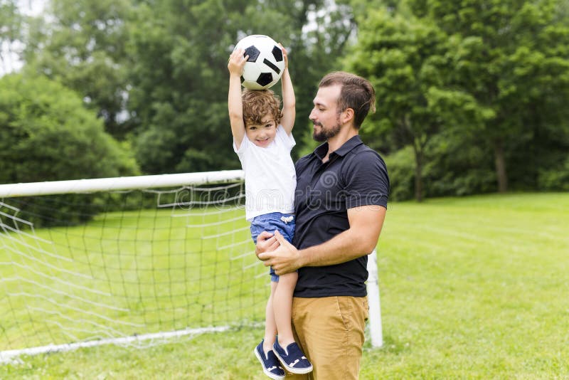 Father with Son Playing Football on Football Pitch Stock Image - Image