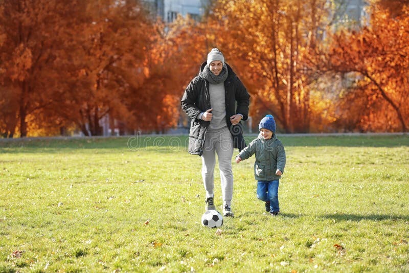 Father and son playing football on pitch stock images Father and son playing football on pitch stock images