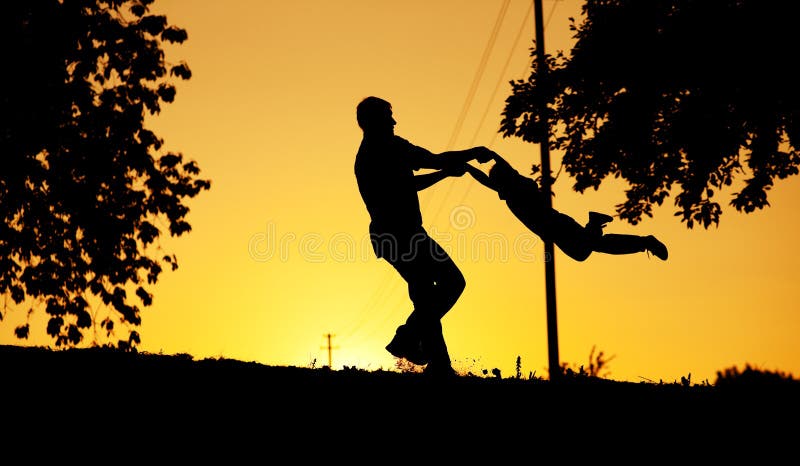 Father and son playing at sunset stock photo