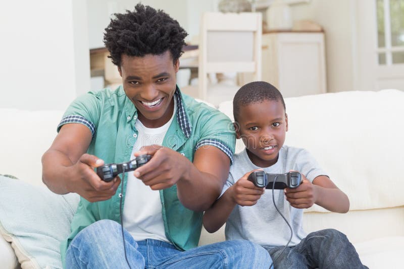 Father and Son Playing Video Games --- Image by © Royalty-…