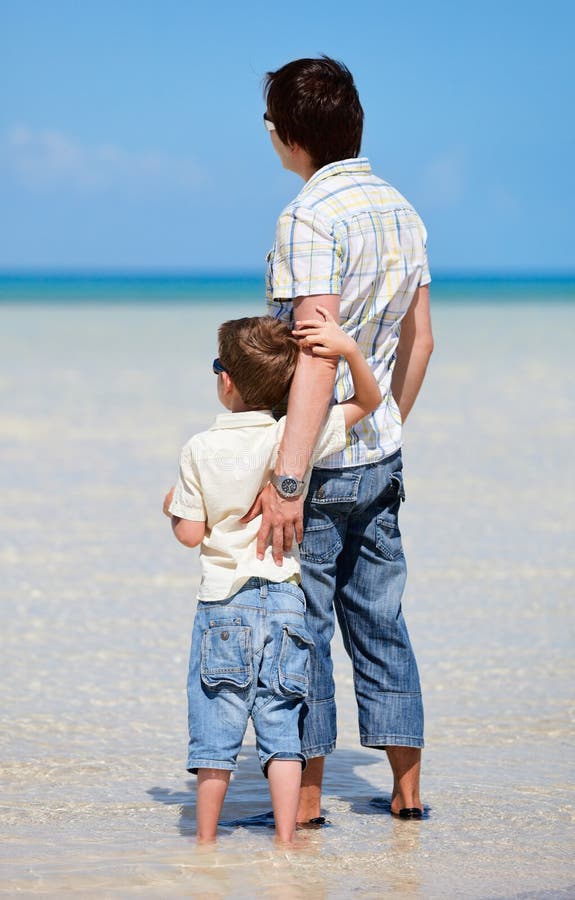 Father and son at shallow water stock photography