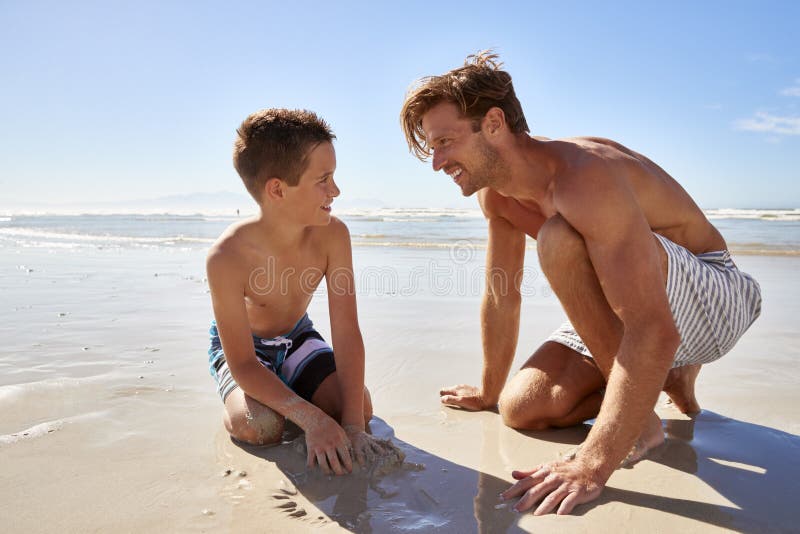 Father And Son On Summer Vacation Playing On Beach Together. 