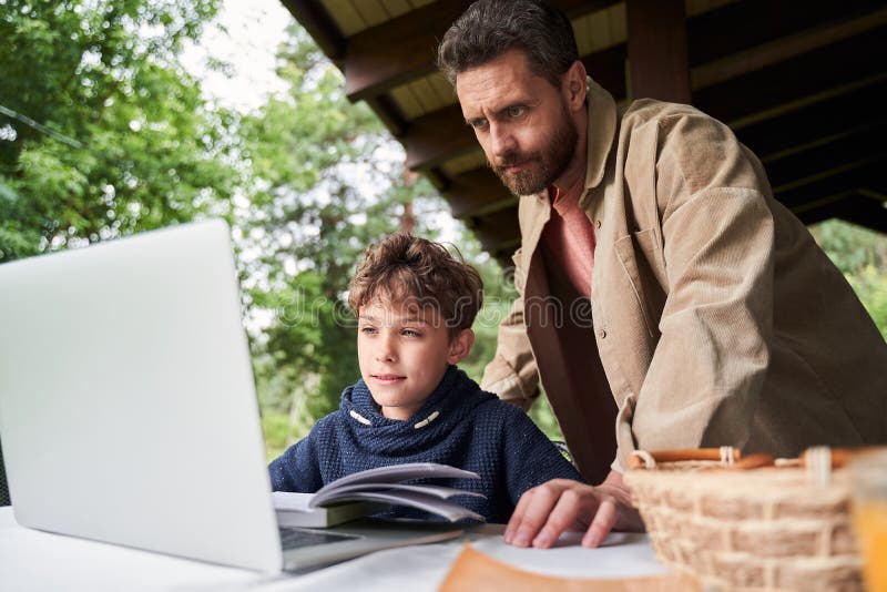 Father and son using laptop while studying outdoors royalty free stock photos