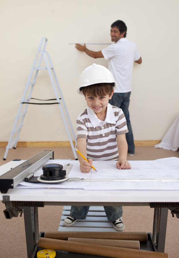 Father and son working with artchitectural plans at home. Father and son working with artchitectural plans at home