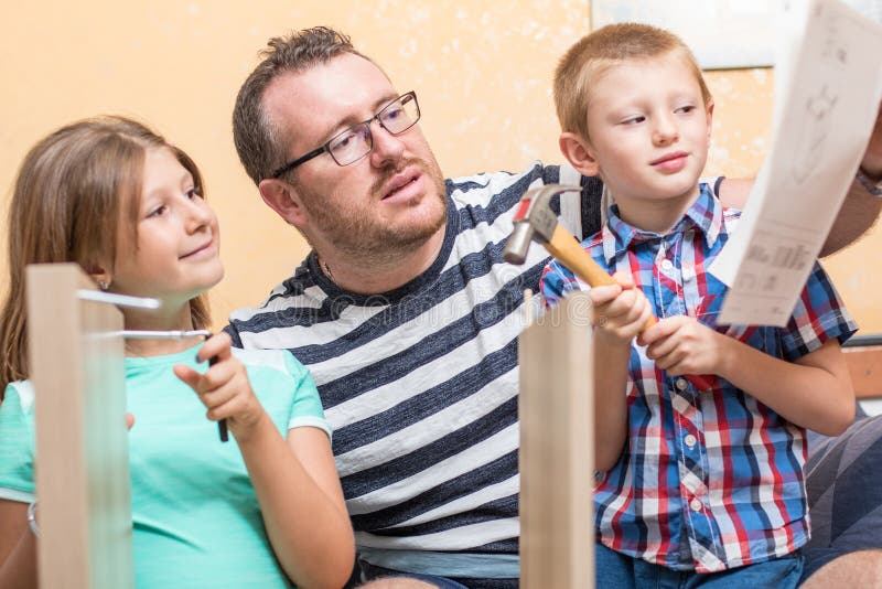 Father and sons are are building the furniture at home