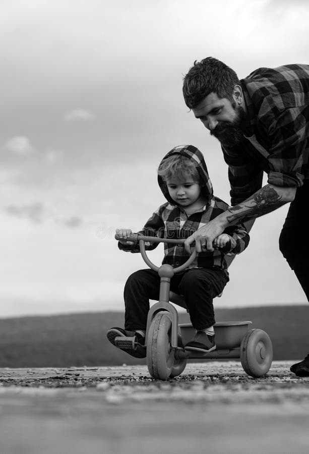 Father Teaching His Son To Ride a Bicycle. Little Boy Learn To Ride a