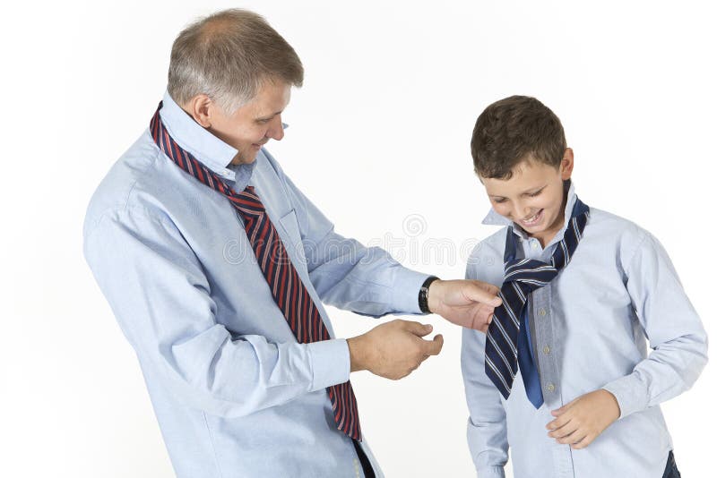 Father is teaching his son to tie a knot on a tie