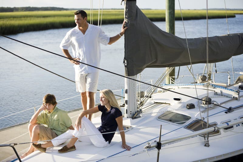 Father and two teenage children relaxing on boat stock photos Father and two teenage children relaxing on boat stock photos