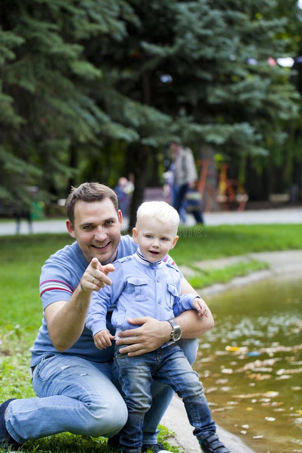 Father with two year old son in summer park. Adult, parent.