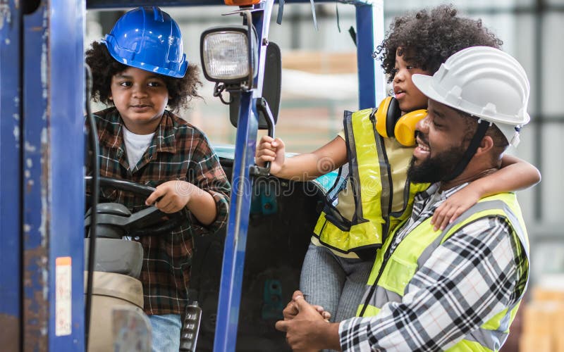 Father wearing safety hard hat, teaching children to drive tractor in factory to support his work as worker, playing, smiling