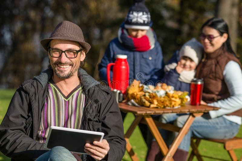 Father working on a picnic with his tablet PC stock images Father working on a picnic with his tablet PC stock images