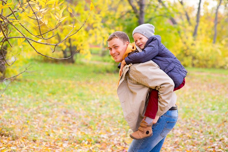 Father With Young Son On his back Autumn Park