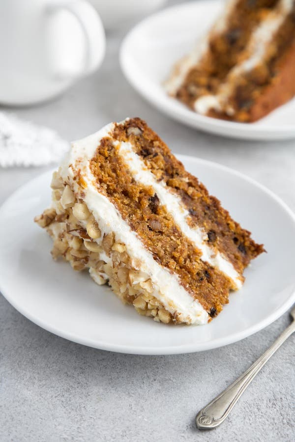 Fatia de bolo de cenoura delicioso com geada do queijo creme e NU fotografia de stock royalty free