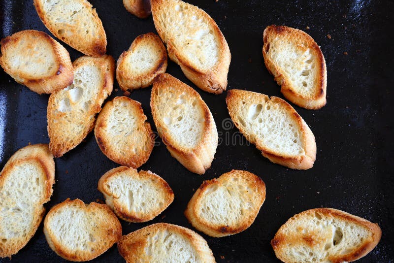 Crispy baked baguette slices on a baking tray, delicious food. Crispy baked baguette slices on a baking tray, delicious food