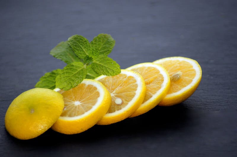 Fatias de limão com hortelã num prato de ardósia imagens de stock royalty free