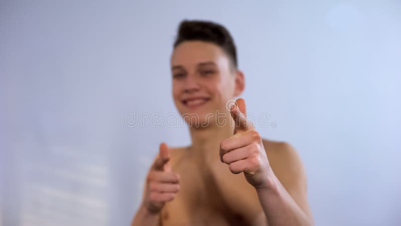 A fatura de sorriso do adolescente escolhe-o gesto no banheiro, fingindo estar fresca foto de stock A fatura de sorriso do adolescente escolhe-o gesto no banheiro, fingindo estar fresca foto de stock