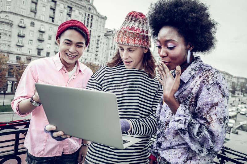 Fată cu pielea închisă emoțională care se uită la ecranul laptopului stock images