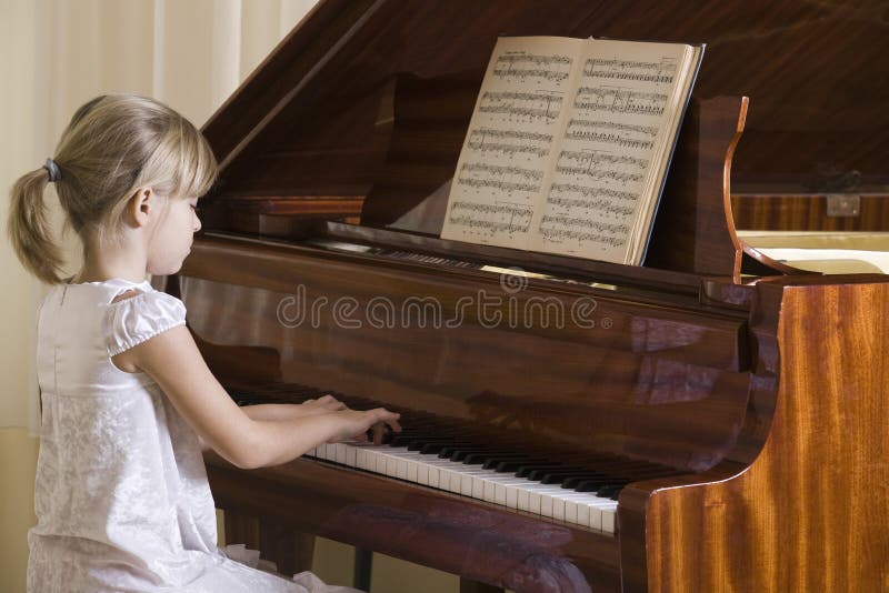 Fată cântând la pian stock images