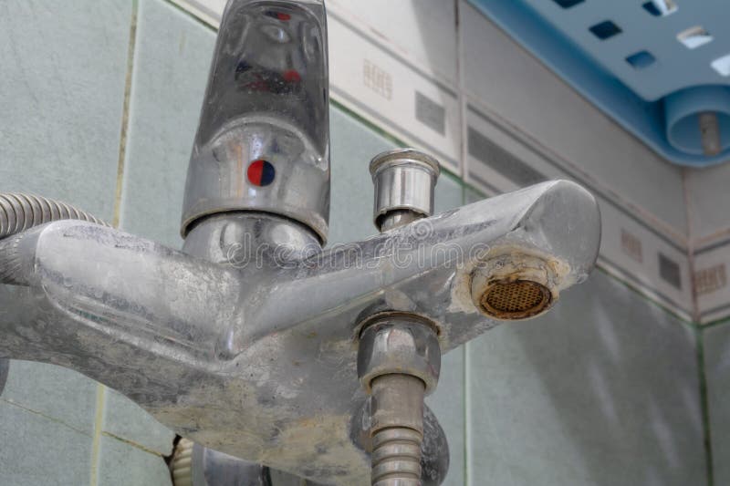 Faucet limescale. Dirty faucet aerator with limescale, calcified shower water tap with lime scale in bathroom, close up. Selective stock photo