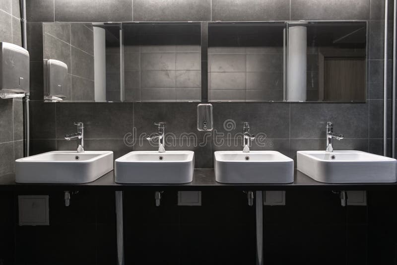 Faucets с уборной washbasin публично в серых цветах стоковое изображение rf Faucets с уборной washbasin публично в серых цветах стоковое изображение rf