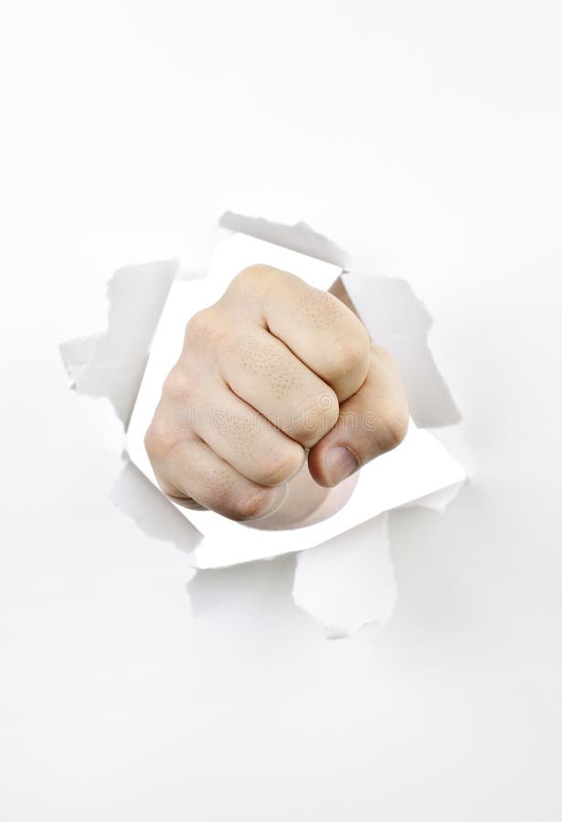 Fist punching through hole in white paper. Fist punching through hole in white paper