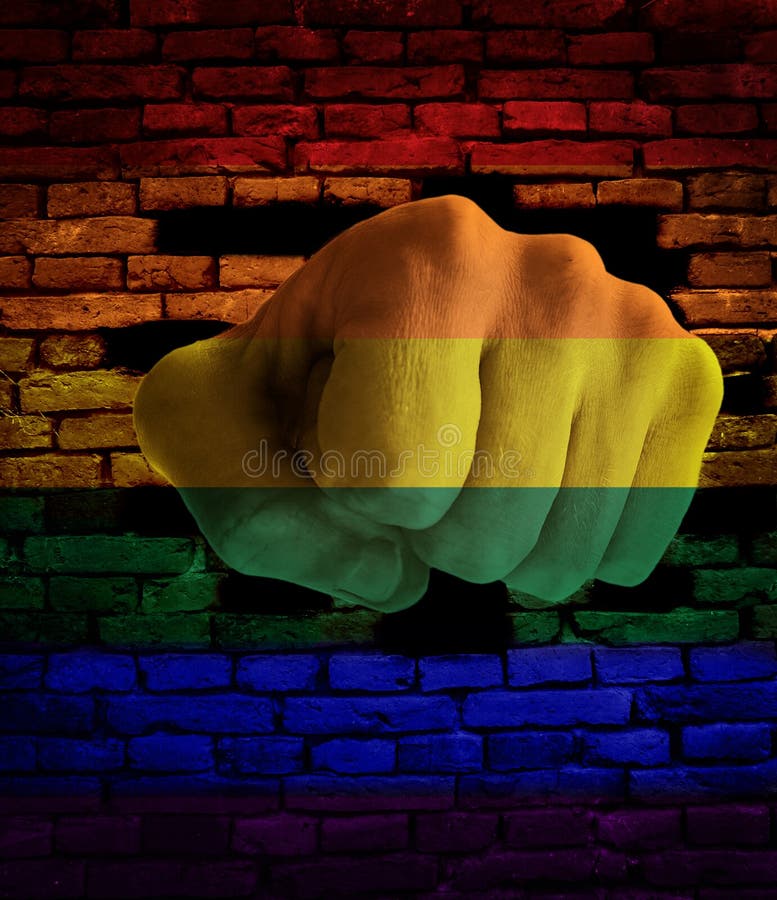 Faust, die durch Regenbogenwand locht lizenzfreie stockbilder Faust, die durch Regenbogenwand locht lizenzfreie stockbilder