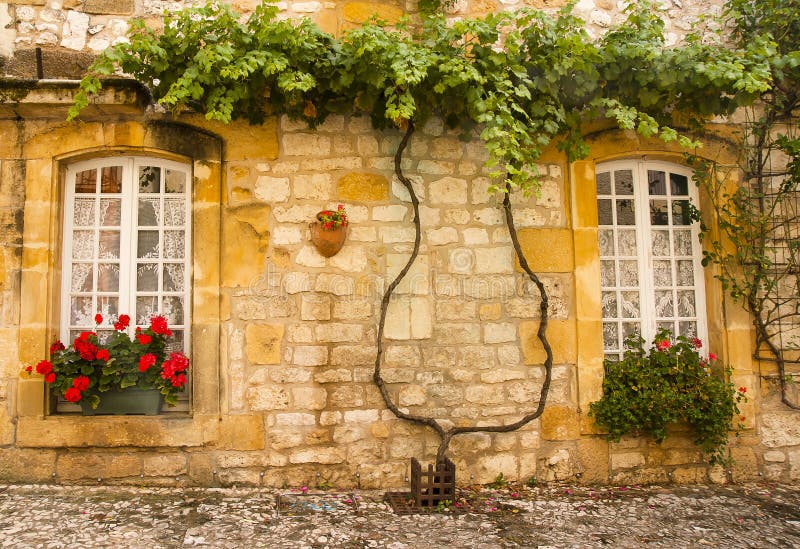 Façade avec des fleurs Monpazier image stock Façade avec des fleurs Monpazier image stock