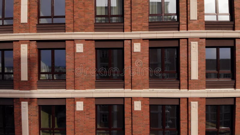 Façade d'un bâtiment en brique de plusieurs étages avec fenêtres. banque de vidéos