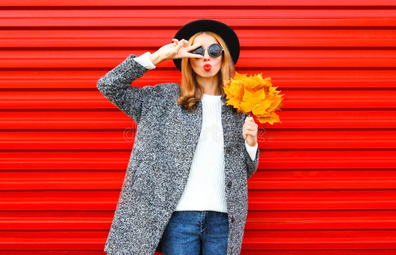 Façonnez la jeune femme d'automne avec les lèvres rouges et les feuilles jaunes d'érable photo stock Façonnez la jeune femme d'automne avec les lèvres rouges et les feuilles jaunes d'érable photo stock