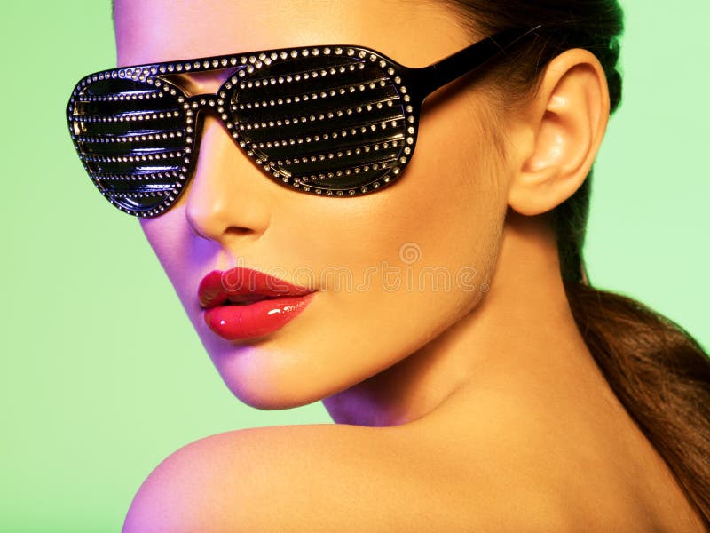 Façonnez le portrait de la femme utilisant les lunettes de soleil noires avec le diamant image libre de droits Façonnez le portrait de la femme utilisant les lunettes de soleil noires avec le diamant image libre de droits