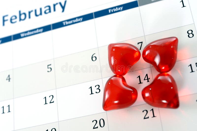 Februari-kalenderpagina en kleine rode harten die valentijnskaartendag merken